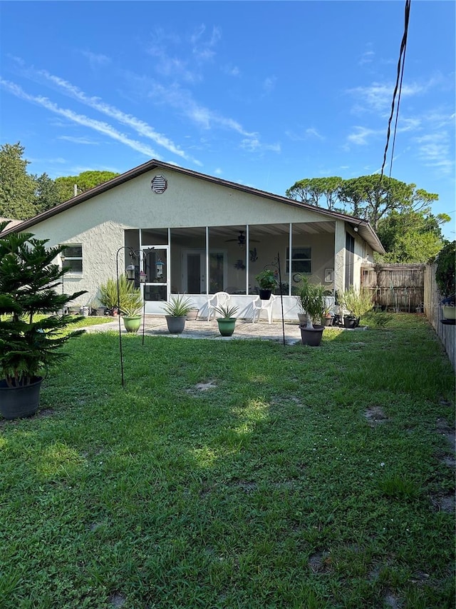 back of property with ceiling fan, a patio area, and a lawn