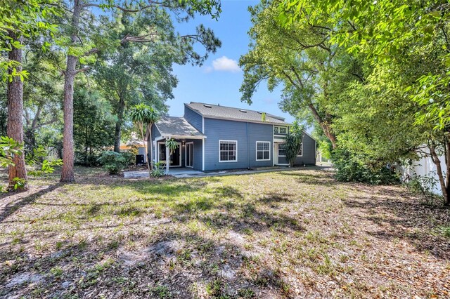 back of property featuring a patio and a yard