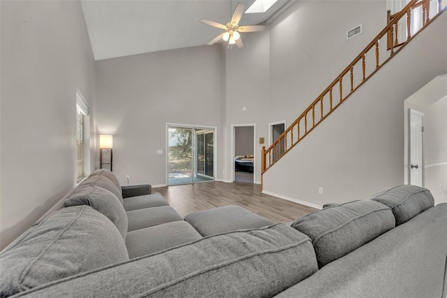 living room featuring ceiling fan, high vaulted ceiling, and hardwood / wood-style floors