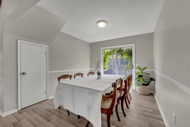 dining room with light hardwood / wood-style floors and a textured ceiling