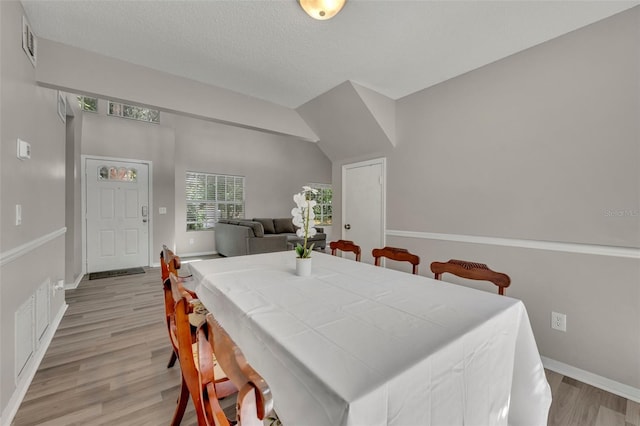 dining area featuring light hardwood / wood-style floors and lofted ceiling