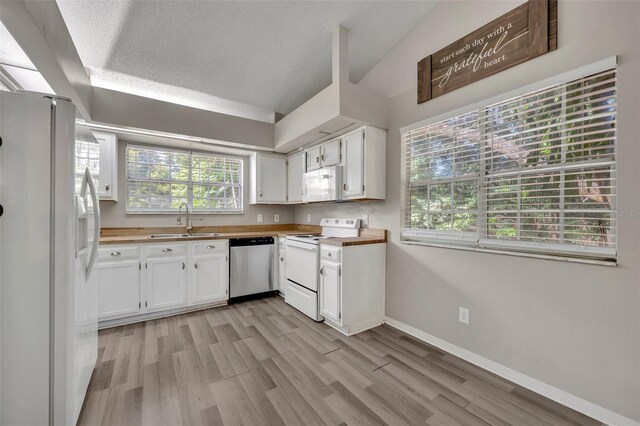 kitchen with sink, light wood-type flooring, white cabinetry, and white appliances