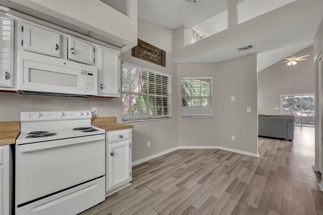 kitchen featuring ceiling fan, white appliances, high vaulted ceiling, and white cabinetry