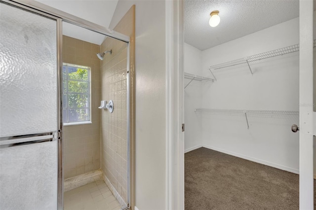 bathroom featuring a textured ceiling and walk in shower