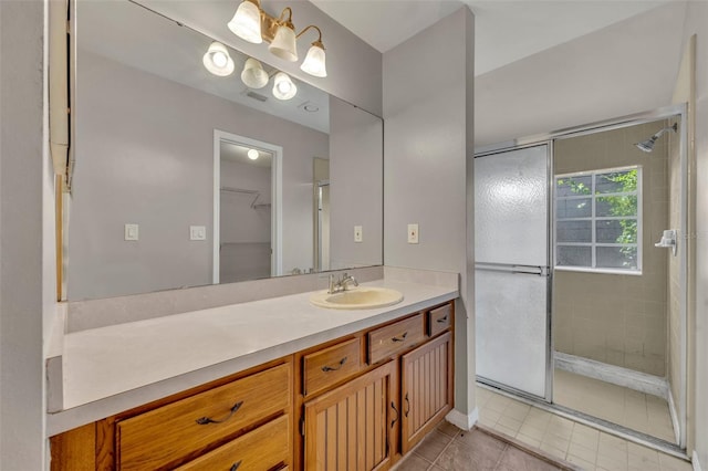 bathroom with tile patterned flooring, walk in shower, and vanity