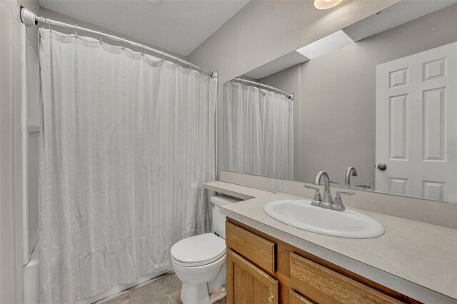 bathroom featuring tile patterned flooring, toilet, and vanity