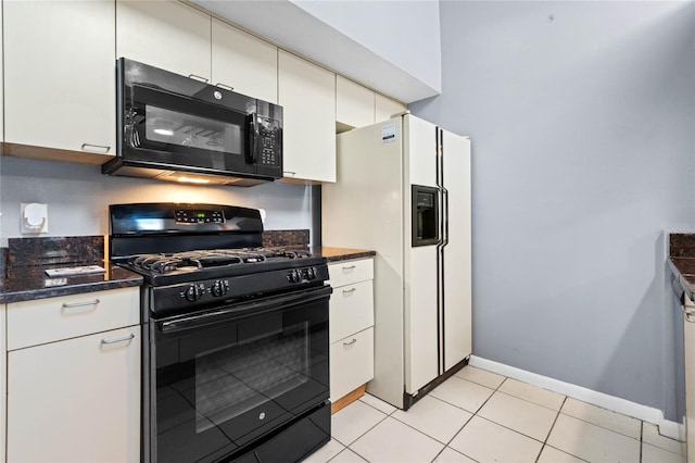 kitchen with black appliances, dark stone countertops, white cabinetry, and light tile patterned flooring