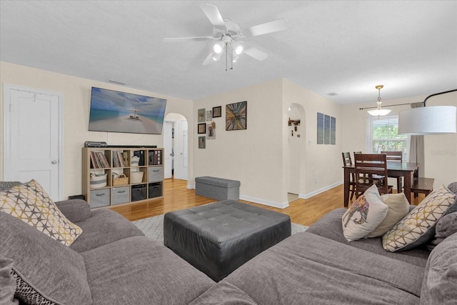 living room featuring ceiling fan and light hardwood / wood-style floors