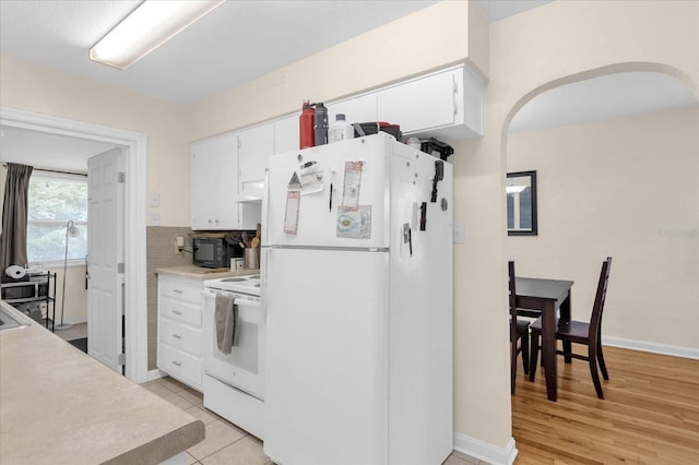 kitchen featuring light wood-type flooring, decorative backsplash, white appliances, and white cabinets