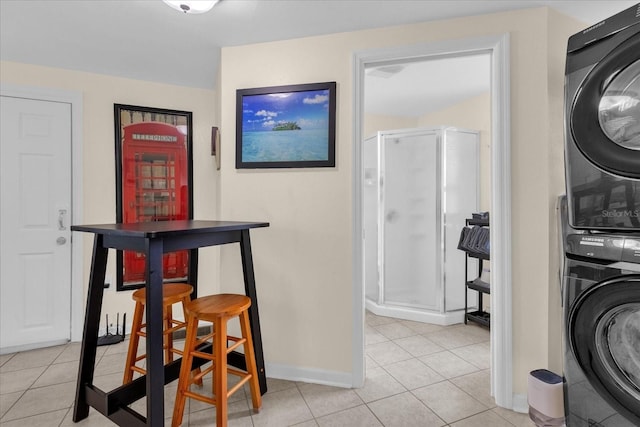 interior space with stacked washing maching and dryer and light tile patterned floors