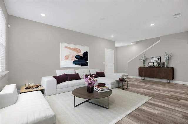 living area featuring light wood-type flooring, baseboards, visible vents, and recessed lighting