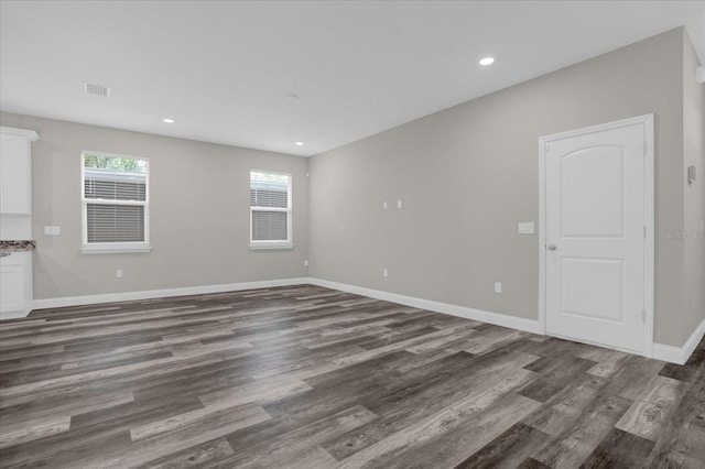 unfurnished room with recessed lighting, dark wood-style flooring, visible vents, and baseboards