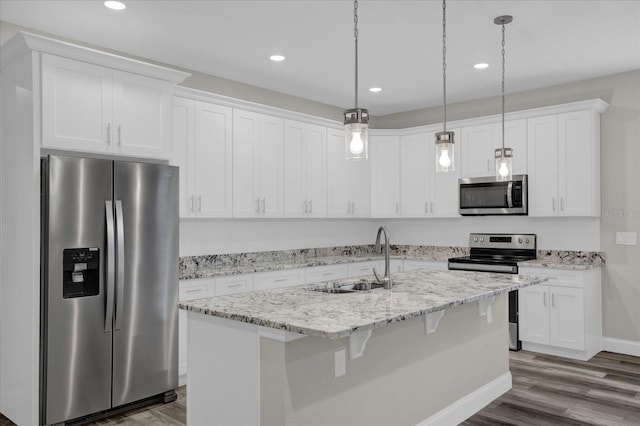 kitchen featuring stainless steel appliances, hardwood / wood-style floors, sink, an island with sink, and white cabinets