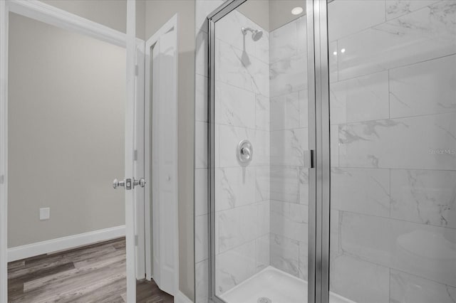 bathroom with hardwood / wood-style flooring and an enclosed shower