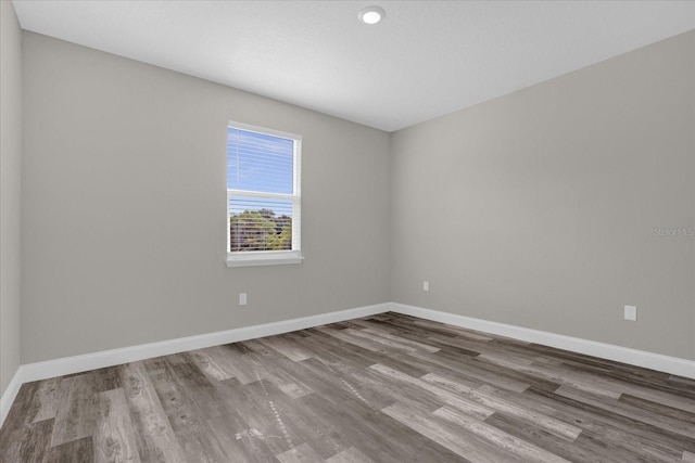 spare room featuring wood finished floors and baseboards