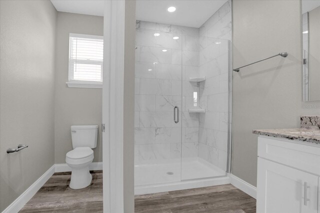 bathroom with hardwood / wood-style flooring, toilet, an enclosed shower, and vanity