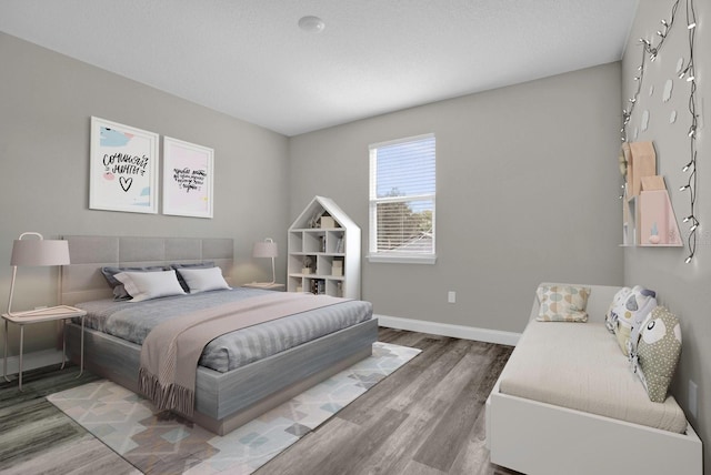 bedroom with baseboards and wood finished floors