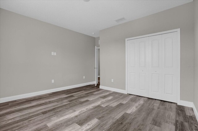 unfurnished bedroom featuring hardwood / wood-style flooring and a closet