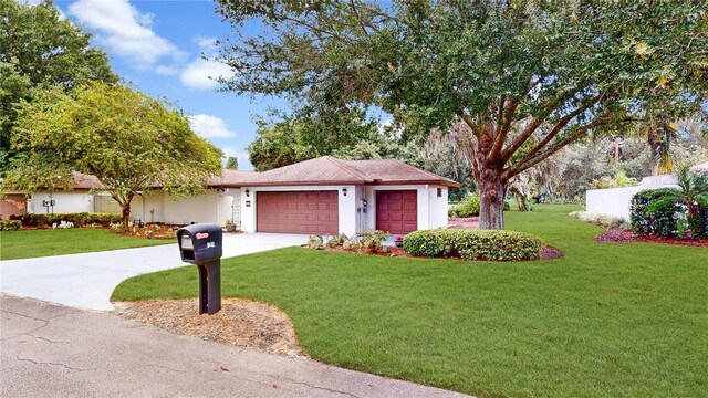 single story home with a garage and a front lawn