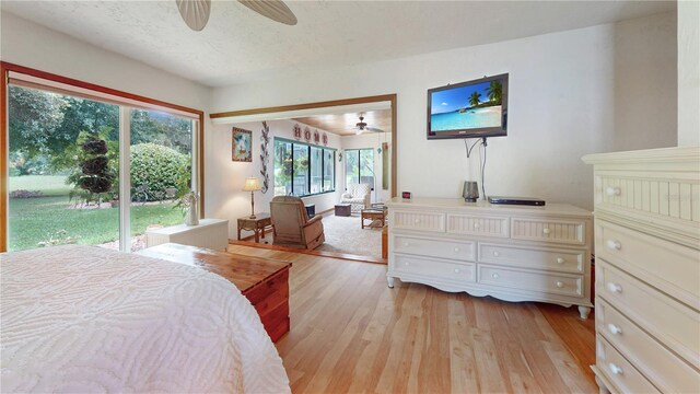 bedroom with light hardwood / wood-style flooring, ceiling fan, and access to exterior