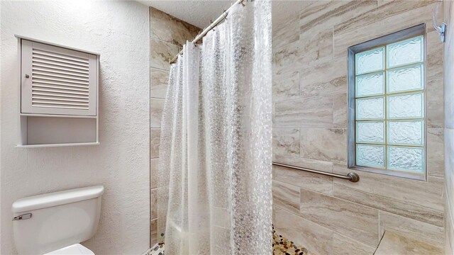 bathroom featuring toilet and a shower with curtain