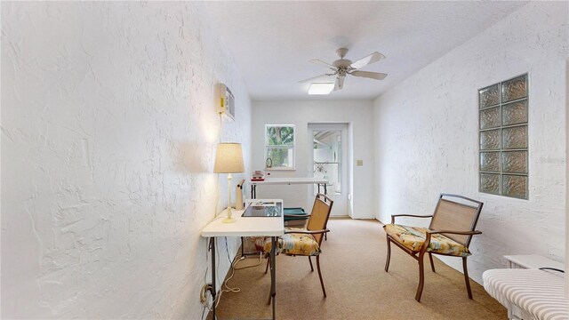 carpeted home office featuring ceiling fan