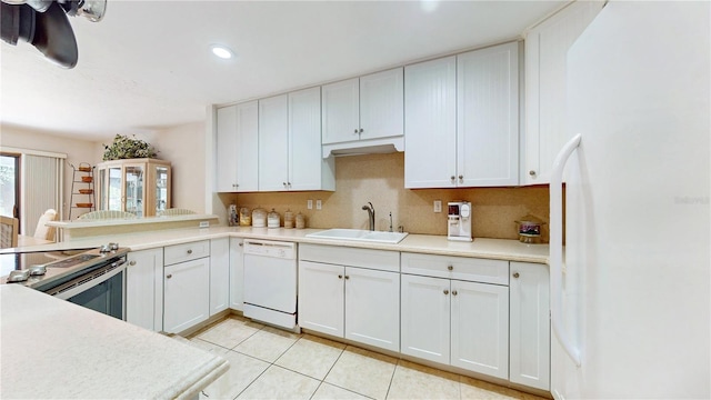 kitchen with sink, backsplash, white cabinetry, and white appliances