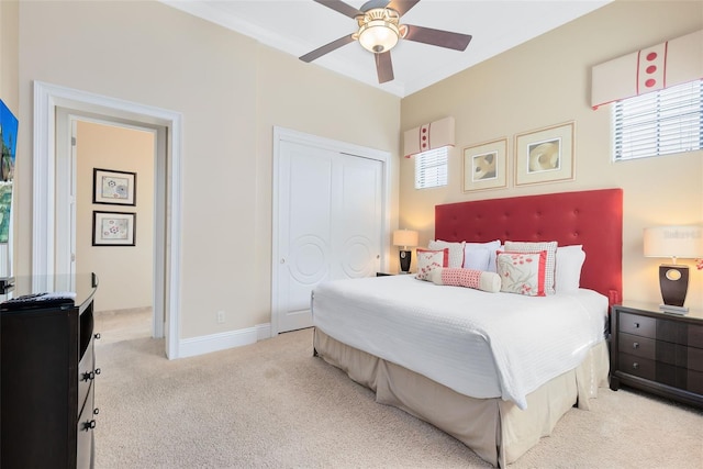 carpeted bedroom with ceiling fan and a closet