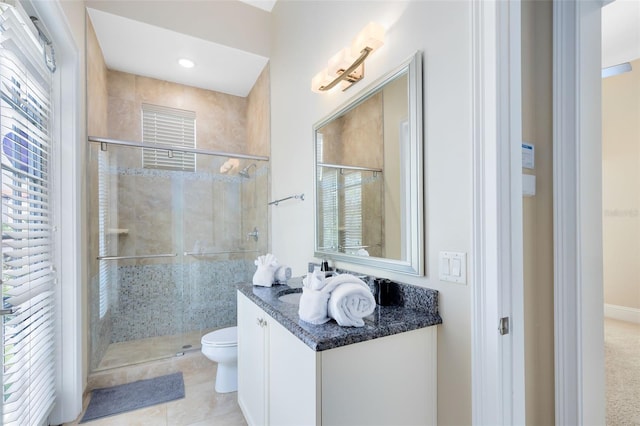 bathroom featuring vanity, toilet, a shower with shower door, and tile patterned flooring