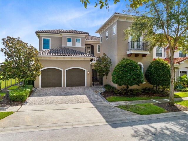 mediterranean / spanish-style house with a garage and a balcony