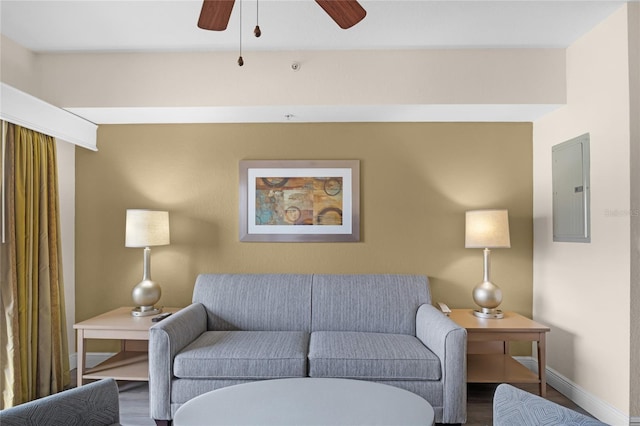 living room with ceiling fan, electric panel, and wood-type flooring