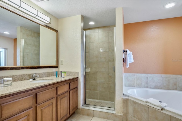 bathroom with tile patterned flooring, separate shower and tub, a textured ceiling, and vanity