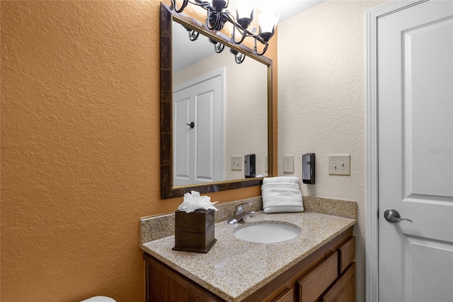 bathroom with vanity and a chandelier