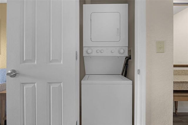 washroom featuring wood-type flooring and stacked washer and dryer