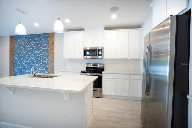 kitchen featuring sink, stainless steel appliances, an island with sink, and tasteful backsplash