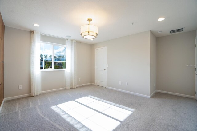 unfurnished room featuring light colored carpet