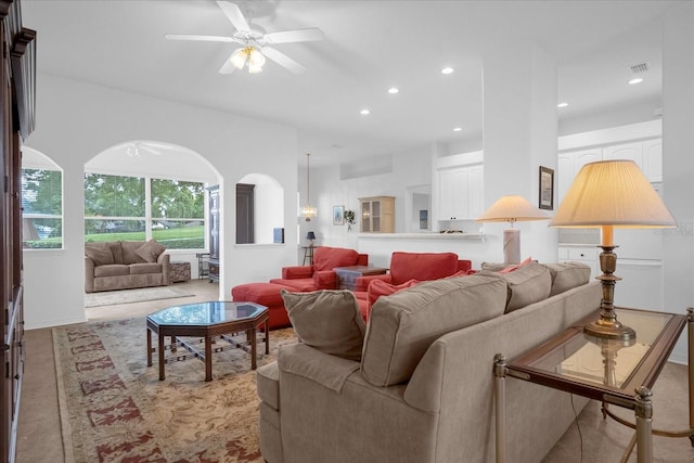 living room with ceiling fan, visible vents, arched walkways, and recessed lighting