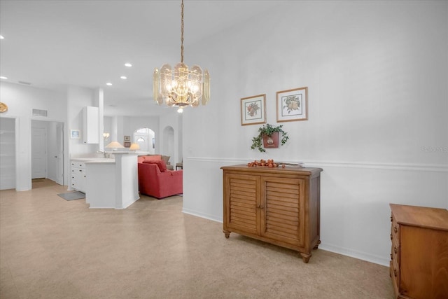 dining area with arched walkways, baseboards, visible vents, and recessed lighting