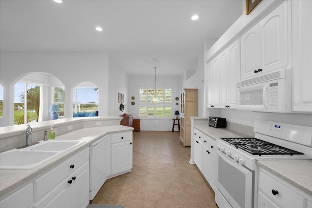 kitchen featuring white appliances, light countertops, and a sink