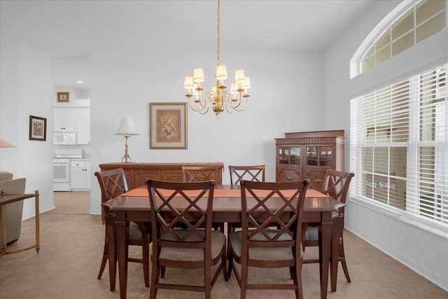 dining space featuring light colored carpet, baseboards, and an inviting chandelier