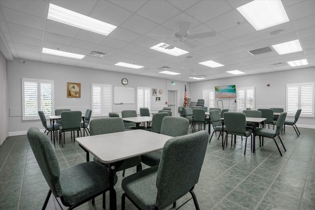 tiled dining area featuring baseboards, visible vents, ceiling fan, and a drop ceiling