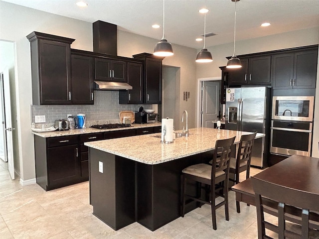 kitchen featuring light tile patterned flooring, backsplash, stainless steel appliances, and a center island with sink