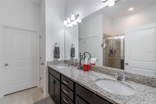 bathroom with tile patterned flooring, double sink vanity, and an enclosed shower