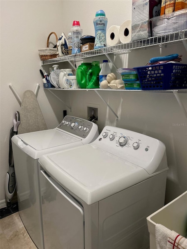 clothes washing area with washer and dryer and light tile patterned floors