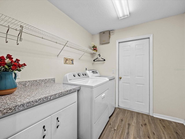 laundry area featuring washer and clothes dryer, a textured ceiling, and light wood-type flooring