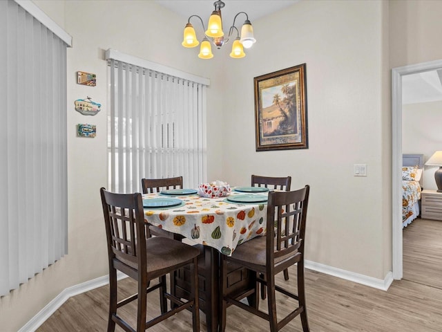 dining area featuring an inviting chandelier and light hardwood / wood-style floors