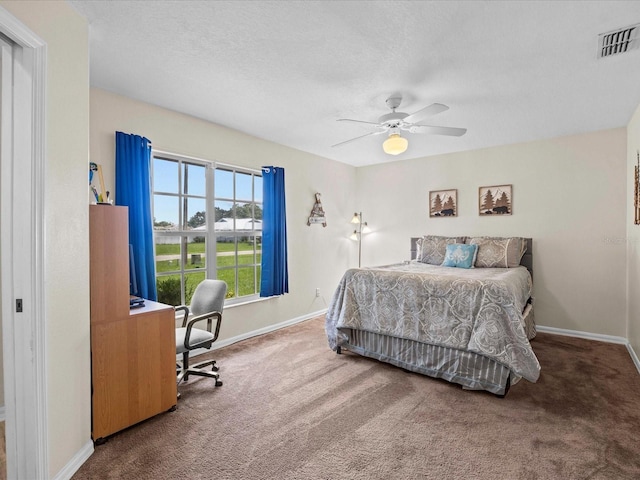 carpeted bedroom featuring a textured ceiling and ceiling fan