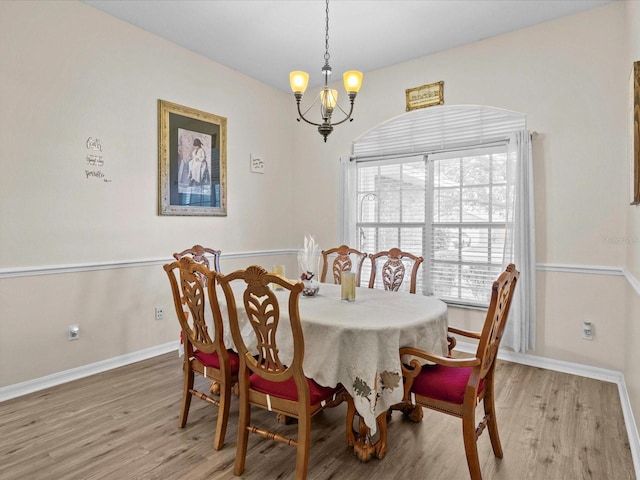 dining space with an inviting chandelier and light hardwood / wood-style floors