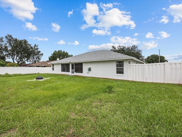 rear view of property with an outdoor fire pit and a lawn