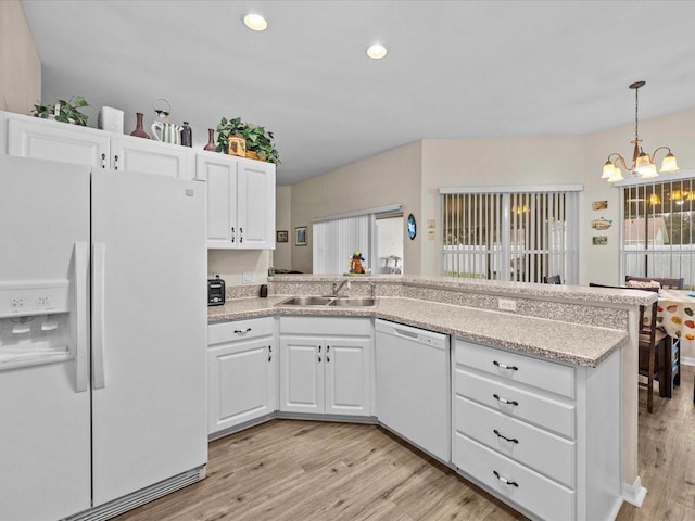 kitchen with white cabinetry, white appliances, sink, and a notable chandelier